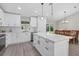 Modern kitchen with white cabinets, stainless steel appliances, island and adjacent dining area at 1449 Overhead St, North Port, FL 34288