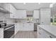 Modern kitchen with white cabinets, stainless steel appliances, and a bright subway tile backsplash at 1449 Overhead St, North Port, FL 34288