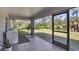 Screened patio featuring tile flooring, fan, and views of the lush backyard at 1449 Overhead St, North Port, FL 34288