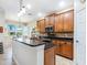 Well-lit kitchen with granite countertops, stainless steel appliances, and a kitchen island with sink at 1545 Maseno Dr, Venice, FL 34292
