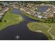 Aerial view of a golf community with homes, lush landscaping, lakes, and golf course fairways at 1572 Jasper Ct, Venice, FL 34292