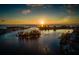 An aerial view of boats cruising the waterway, with a sunset and beautiful waterfront homes at 1572 Jasper Ct, Venice, FL 34292