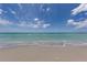 Calm beach scene with gentle waves meeting the shore under a partly cloudy sky at 1572 Jasper Ct, Venice, FL 34292