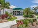 Waterford Sports Club entrance with a green awning, lush landscaping, and a welcoming facade at 1572 Jasper Ct, Venice, FL 34292