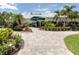 Waterford Sports Club entrance featuring manicured landscaping, a green awning, and a welcoming facade at 1572 Jasper Ct, Venice, FL 34292