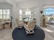 Dining room with circular area rug, table and chairs with lots of natural light and view of the golf course at 1572 Jasper Ct, Venice, FL 34292