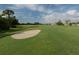 Scenic golf course view showcasing a sand trap, lush green fairway, and clear blue skies at 1572 Jasper Ct, Venice, FL 34292