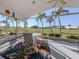 Screened lanai featuring outdoor seating and expansive views of a green lawn with palm trees at 1572 Jasper Ct, Venice, FL 34292