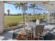 Screened lanai featuring outdoor seating and expansive views of a green lawn and palm trees at 1572 Jasper Ct, Venice, FL 34292
