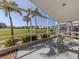 Screened lanai featuring outdoor seating and expansive views of a green lawn with palm trees at 1572 Jasper Ct, Venice, FL 34292