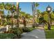 Scenic street view with lush landscaping, palm trees, and decorative hanging flower baskets at 1572 Jasper Ct, Venice, FL 34292