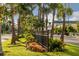 Charming street view featuring manicured landscaping, palm trees, and wrought-iron fencing at 1572 Jasper Ct, Venice, FL 34292
