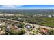 Serene aerial view showcasing a charming blue home nestled among lush greenery, near a tranquil waterway at 1596 Landfall Dr, Nokomis, FL 34275