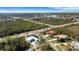 Scenic aerial shot highlighting a blue home by the water, surrounded by lush greenery, with a white circular border at 1596 Landfall Dr, Nokomis, FL 34275
