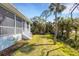 The backyard is enhanced by a screened lanai and lush greenery for added privacy and shade at 1596 Landfall Dr, Nokomis, FL 34275