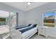 Bright bedroom featuring a window, sliding glass doors to the lanai, and white furniture at 1596 Landfall Dr, Nokomis, FL 34275