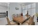 Well-lit dining room showcasing a wooden table, decorative lighting, and large windows at 1596 Landfall Dr, Nokomis, FL 34275