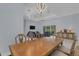 Open-concept dining area with a large wooden table, modern lighting, and views into the living space at 1596 Landfall Dr, Nokomis, FL 34275
