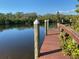 Scenic dock on tranquil water, framed by lush trees, offering serenity and relaxation at 1596 Landfall Dr, Nokomis, FL 34275