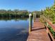 Charming wooden dock with guide posts that leads into the tranquil water at 1596 Landfall Dr, Nokomis, FL 34275