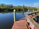 Waterfront property featuring a wooden dock with railings, offering access to the serene water at 1596 Landfall Dr, Nokomis, FL 34275