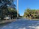 Gated entrance for the community, featuring a sign, black iron gate, and surrounding trees and shrubs at 1596 Landfall Dr, Nokomis, FL 34275