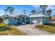 Charming light blue single-story home with a metal roof, brick driveway, and well-manicured landscaping at 1596 Landfall Dr, Nokomis, FL 34275