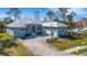 Attractive single-story home featuring a metal roof, lush lawn, and mature trees, providing both beauty and shade at 1596 Landfall Dr, Nokomis, FL 34275