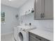 Functional laundry room includes washer, dryer, storage, and folding counter at 1596 Landfall Dr, Nokomis, FL 34275