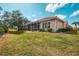 Well-maintained home exterior with lush lawn, mature landscaping, and a screened-in porch at 1723 San Silvestro Dr, Venice, FL 34285