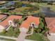 Stunning aerial view of a home with a red tile roof, surrounded by lush landscaping and a serene lake at 190 Montelluna Dr # North, North Venice, FL 34275