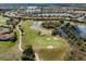 Scenic aerial shot of the golf course with lush green fairways, sand traps, and surrounding ponds in a residential area at 190 Montelluna Dr # North, North Venice, FL 34275