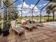 Relaxing covered patio featuring stylish lounge chairs with an amazing water view beyond the screened enclosure at 190 Montelluna Dr # North, North Venice, FL 34275