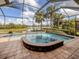 Inviting screened-in pool with a built-in spa and tranquil water views overlooking a lush landscape at 190 Montelluna Dr # North, North Venice, FL 34275