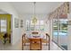 Bright breakfast nook with a wood table, decorative accents, and sliding glass doors leading to the pool area at 1904 Canary Island St, Venice, FL 34292