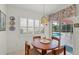 Sunlit breakfast nook features a round table, shuttered windows, and access to the outdoor pool area at 1904 Canary Island St, Venice, FL 34292