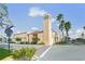 View of a tall commercial building with street access and crosswalk, surrounded by lush landscaping and palm trees at 1904 Canary Island St, Venice, FL 34292