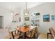 Bright dining room features a wooden table, six chairs, and a decorative chandelier at 1904 Canary Island St, Venice, FL 34292
