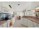 Efficient kitchen with ample cabinet space, pink countertops, and white appliances at 1904 Canary Island St, Venice, FL 34292