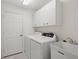 Functional laundry room equipped with modern washer and dryer, storage cabinets, and a utility sink at 1904 Canary Island St, Venice, FL 34292