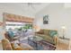 Comfortable living room with sliding glass doors to the pool area, and neutral decor at 1904 Canary Island St, Venice, FL 34292