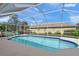 Screened-in pool with a clear blue water and ample deck space for outdoor lounging on a sunny day at 1904 Canary Island St, Venice, FL 34292