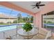 Enclosed patio with a glass table and chairs, with a scenic view of the refreshing blue swimming pool at 1904 Canary Island St, Venice, FL 34292