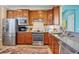 Modern kitchen featuring stainless steel appliances, wood cabinetry, and granite countertops at 19249 Isadora St, Venice, FL 34293