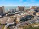 An aerial view showcases the building's architecture with nearby beachfront and convenient parking at 200 The Esplanade N # B10, Venice, FL 34285