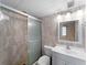A bathroom features a tiled walk-in shower, toilet, and vanity with framed mirror and updated fixtures at 200 The Esplanade N # B10, Venice, FL 34285