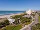 Aerial view of a beachside area, with sand, buildings, palm trees, and a busy road at 200 The Esplanade N # B10, Venice, FL 34285