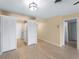 An open living room with wood floors, a ceiling fan, and an adjoining kitchen through closet doors at 200 The Esplanade N # B10, Venice, FL 34285