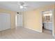 A main bedroom with wood floors, a ceiling fan, a closet, and an en suite bathroom at 200 The Esplanade N # B10, Venice, FL 34285