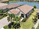 Lovely house with large lawn, brick driveway, and tile roof near a tranquil lake at 26825 Weiskopf Dr, Englewood, FL 34223